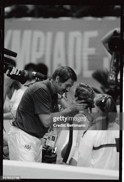Phoebe Mills of the United States is greeted by her coach Bela Karoly Sunday after her bronze medal winning performance on the balance beam.