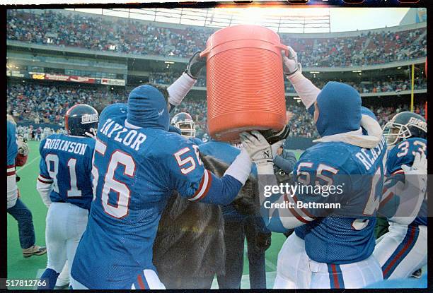 Giants' Lawrence Taylor and Gary Reasons get ready to give coach Bill Parcells a Gatorade shower after winning NFC East title.