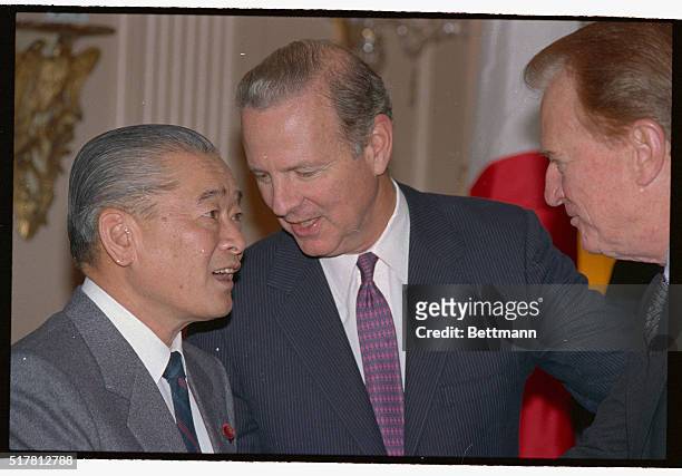 Japanese Prime Minister Noboru Takeshita listens to Secretary of State James Baker here, as the two officials visit prior to a luncheon at the State...