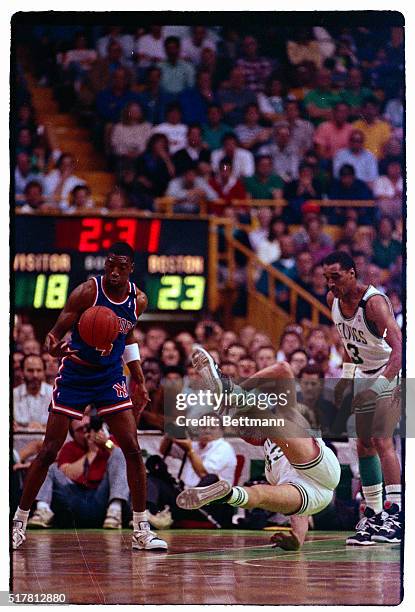 Boston's Larry Bird falls to the parquet floor 5/6 after being fouled during first period action at Boston Garden. The Knicks Johnny Newman makes the...