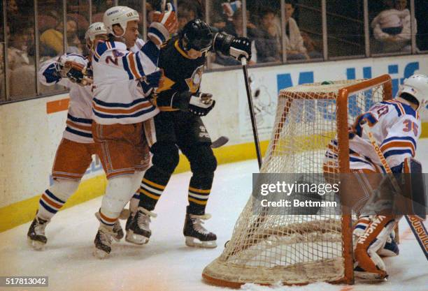 Mario Lemieux of the Pittsburgh Penguins shoots the puck between the legs of New York Ranger's goalie Mike Richter to score a goal in the first...