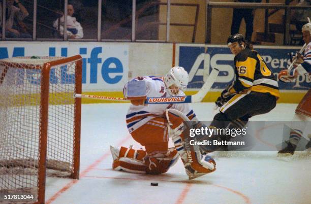 Mario Lemieux of the Pittsburgh Penguins shoots the puck between the legs of New York Ranger's goalie Mike Richter to score a goal in the first...