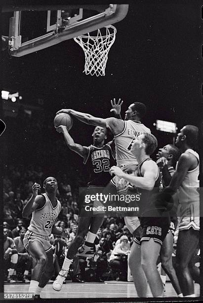 Arizona's Sean Elliot, winces as his shot attempt is blocked by Georgetown's Jonathan Edwards. Arizona's Tom Tolbert, watches the action which...