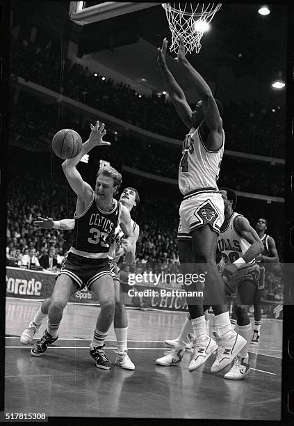 Celtics' Larry Bird has the ball punched out of his hands by Bulls' John Paxson during action in the second half of this first round playoff game,...