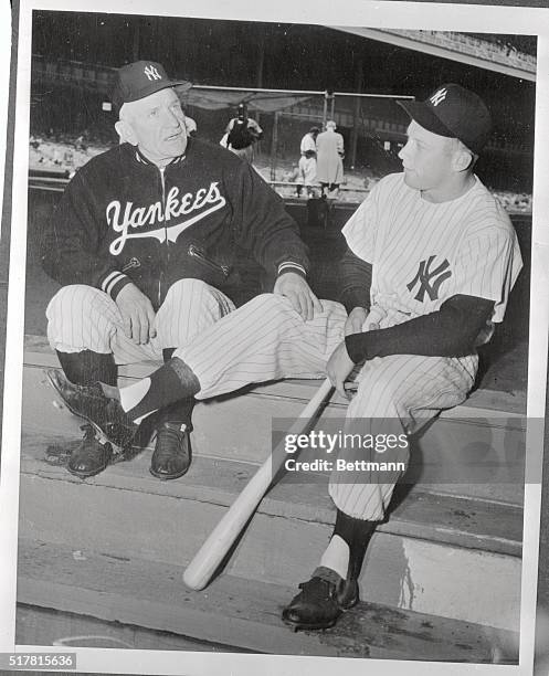 Yankee manager Casey Stengel asks star centerfielder Mickey Mantle how his bad knee feels before game time at Yankee Stadium today. Mantle, who has...