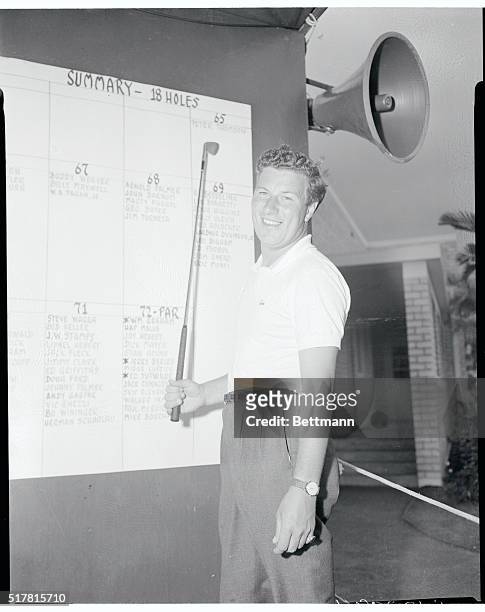 Miami Beach, Florida: Peter Thomson, Australian holder of the British Open golf crown, happily examines the scoreboard after he carved out a seven...