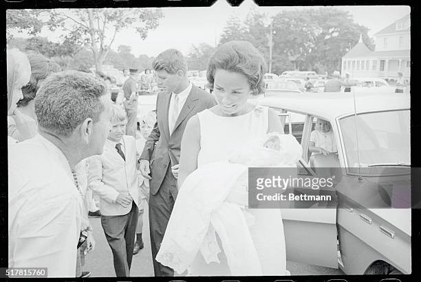 Mrs. Robert Kennedy shows her little son, Christopher George, to bystanders as she arrives at St. Francis Church here, July 19th, for the baby's...