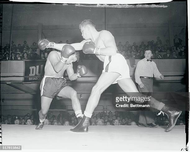 Ray Portilla ducks under the right of Carlos Ortiz during the third round of their lightweight bout at St. Nick's tonight. Ortiz of New York pounded...