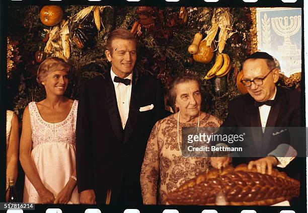At banquet in honor of Israeli Premier Golda Meir, N.Y. Mayor John V. And Mrs. Lindsay look on with Mrs. Meir as Rabbi Emanuel Rackman cuts challah...