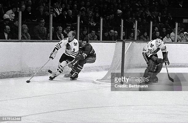 Bobby Hull , Chicago Black Hawks, battles Serge Savard , Montreal Canadiens, for the puck behind the net.