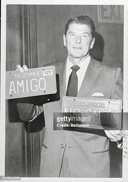 Los Angeles, Calif.: Gov. Ronald Reagan holds up the first and second personalized license plates issued. Plates will finance a Los Angeles-Ventura...