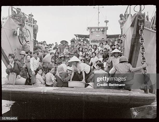 South Vietnamese Navy landing craft fully loaded with refugees from hue, 370 miles northeast of Saigon, ferry additional numbers of people to Danang...