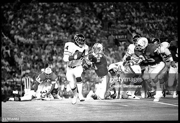 Chicago's Running Back, Walter Payton , brushes off a flying tackle attempt on his 35-yard line by Miami's, Vern DenHarder (830, during a first...