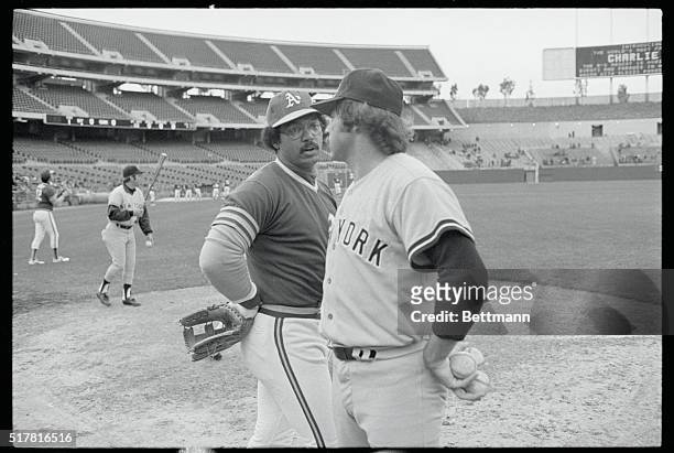 Oakland, Calif.: New York Yankees pitcher Jim "Catfish" Hunter gets together with old teammate, Oakland A's Reggie Jackson before the start of their...