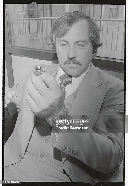 Catfish Hunter, who pitches game of the World Series for the Yankees, shows World Series ring he won with the Oakland A's and which he hopes to match...