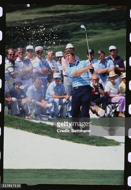 Tom Watson, defending Masters champion, hits out of a trap on the second hole.