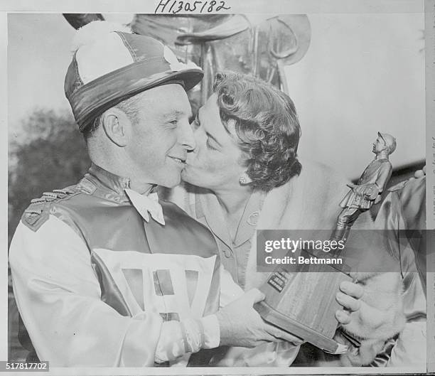 Jockey Johnny Adams is kissed by his wife, Pat, after he was presented with the seventh annual Woolf Memorial Trophy at Santa Anita. Adams was...