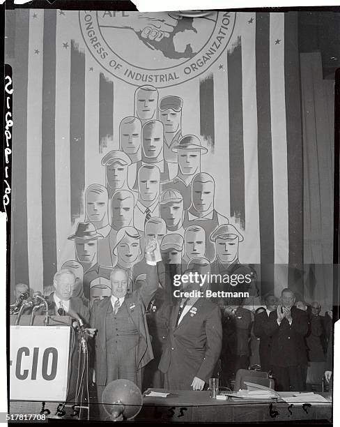 George Meany , who was president of the American Federation Labor before the merger with the CIO, has his hands held by Walter Reuther, who was...