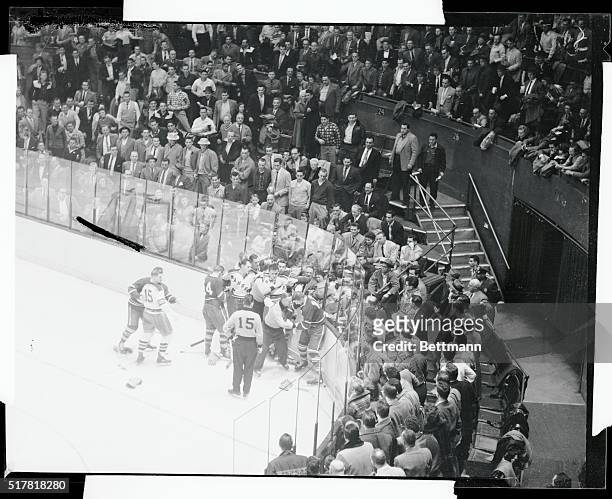 An official steps between Eric Nesterenko, , of the Maple Leafs and Jack Evans, , of the Rangers, after the pair had started a fist fight during the...