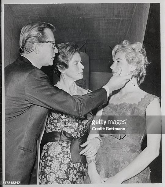 In Spek-shun. San Francisco: Ingrid Bergman , film star, watches as her husband, Lars Schmidt wipes a spec from his step-daughter Jenny's face here....