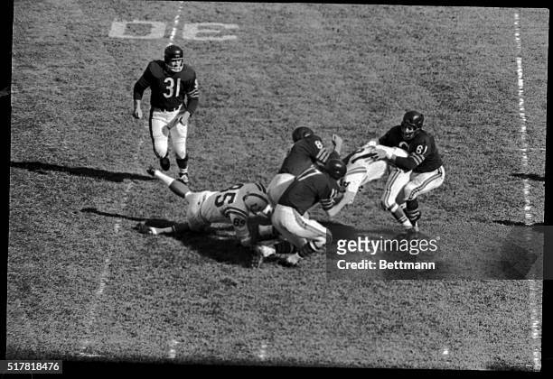 Three Bears tacklers combine their efforts to bring down Colts Johnny Unitas after he made end run for a 9 yard gain during the 3rd quarter of the...