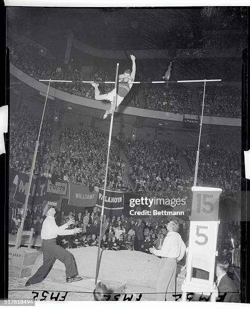 Trackmen roar approval as Don Bragg clears the bar 15 feet 5 1/4 inches high for a new meet and Garden record in the Knights of Columbus games. Bragg...