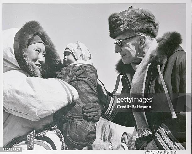 An Eskimo woman introduces her son to Canada's Governor General Vincent Massey as he stopped to meet the inhabitants of a small settlement on the...