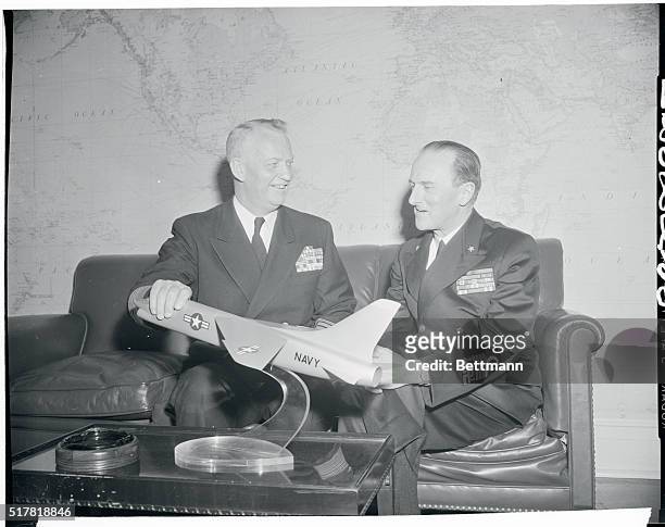 Admiral Arleigh Burke, left, chief of Naval Operations, discusses a model of a new jet fighter for aircraft carriers with his Italian counterpart,...