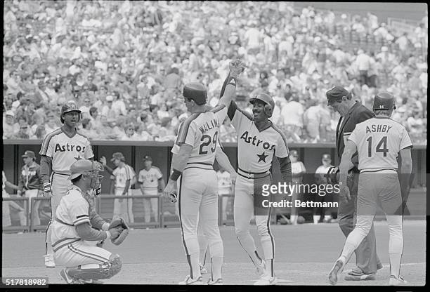 Cincinnati: - Houstons' Kevin Bass gets a congratulatory high five from teammate Denny Walling, one of three players Bass batted in, for a ninth...