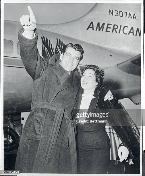 Actor Rory Calhoun points out the sights at Idlewild Airport to his pretty wife, actress Lita Baron before boarding an American Airlines flagship for...