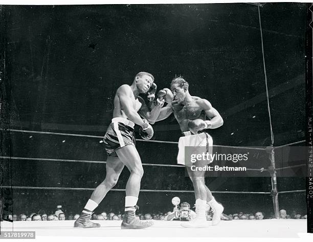 Cuban welterweight Isaac Logart, white trunks, trades punches with Virgil Akins as they both send rights to the head in the opening round of their...