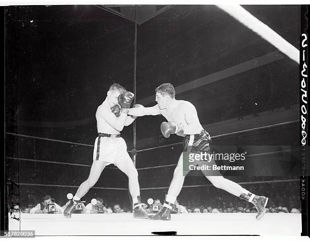 Rocky Castellani comes through with a hard right to the jaw which makes John L. Sullivan wince in the eighth round of their middleweight bout at the...