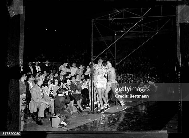 Boston and Minneapolis players engage in a little roughhouse during the second half of tonight's first game at Madison Square Garden before a group...