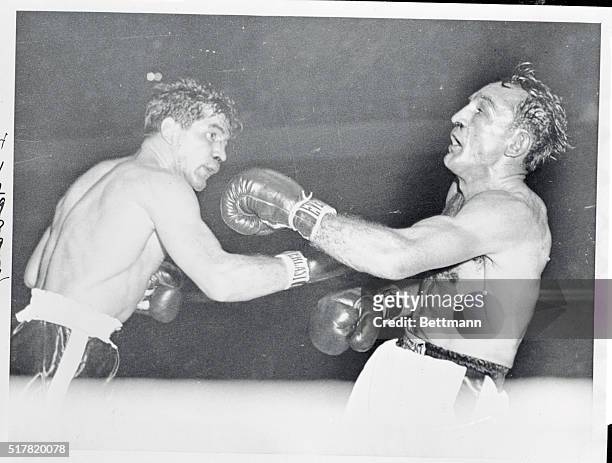 Challenger Tony Demarco , rocks welter king Carmen Basilio with a right in the eighth round of their title bout at Boston Garden last night. Basilio...