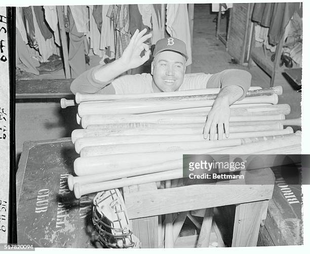 Heavy hitting Duke Snider who batted in 42 homers last season gives the "okay" sign as he peers over a pile of ammunition at the Vero Beach spring...