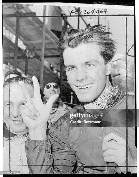 Tony Sailer of Austria, who became the "Glamor Boy" of the winter Olympics, holds up three fingers to indicate his Gold Medal score after he won the...
