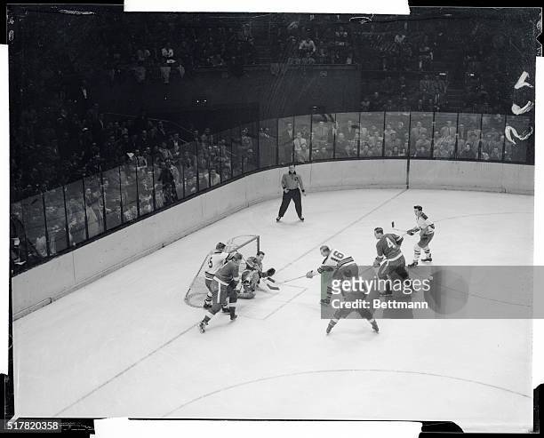 Dave Creighton of the Rangers drives the puck past Detroit Red Wings goalie Glen Hall in the first period of hockey game at the Garden. Blurred...