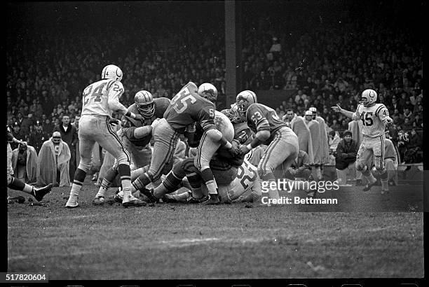 San Francisco Forty Niner, Leo "The Lion" Nomellini earns his nickname as he is about to pounce on the frame of Baltimore quarterback Johnny Unitas...