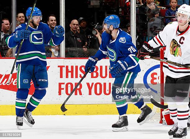 Linden Vey and Chris Higgins of the Vancouver Canucks celebrate a goal by Alexandre Burrows of the Canucks in front of Jonathan Toews of the Chicago...