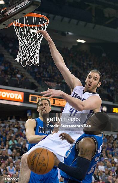 Sacramento Kings center Kosta Koufos goes high for an alley-oop, but the ball is knocked away by Dallas Mavericks guard Wesley Matthews on Sunday,...