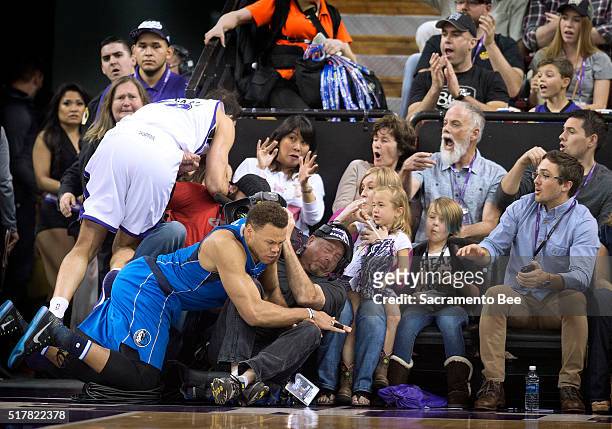 Sacramento Kings forward Omri Casspi and Dallas Mavericks guard Justin Anderson go into the crowd at the end of the third quarter on Sunday, March 27...