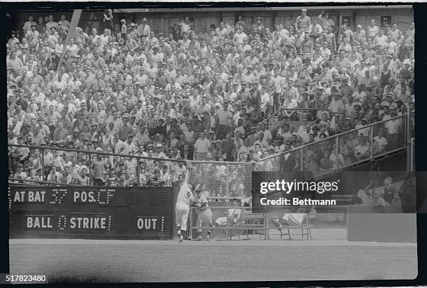 Teammates in the bullpen calmly look on, Yankee right fielder Roger Maris reaches way up to snare a line drive off the bat of Cleveland's Jim...