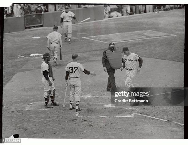 Ted Williams of the Red Sox is greeted after hitting a home run in the second inning of the Boston-Washington opener here. It was Ted's 493rd home...