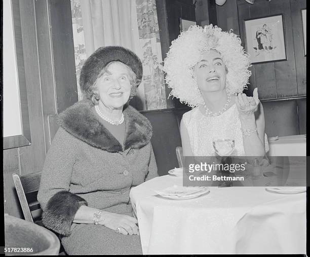 New York: The Animated Miss Crawford. Her face framed by a large frilly hat, Miss Joan Crawford holds an animated conversation during USO banquet at...