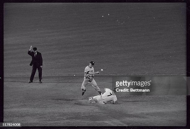 Yankee slugger Mickey Mantle starts into second, as Chuck Cottier of the Washington Senators rears back to throw to first, completing a double play...
