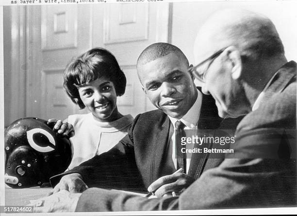 It's a three-way smile as Gale Sayers agrees to become a member of the Chicago Bears. Sayers, Bears' second draft choice, a star at the Kansas...