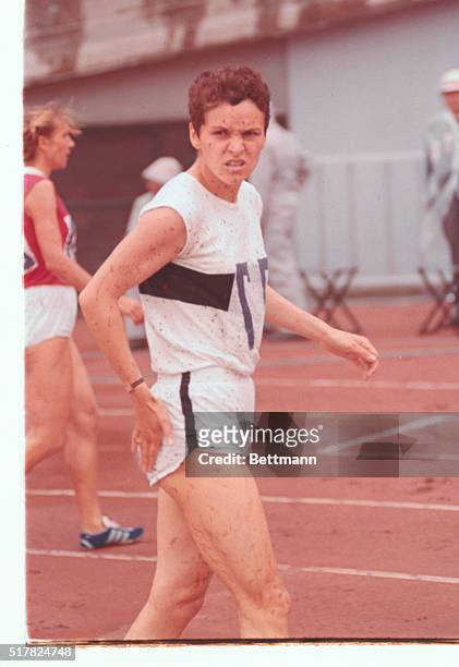 Japan, Tokyo: Track...runner in the women's 800 meter, #77, Anita worner of Germany, is mud covered after race.