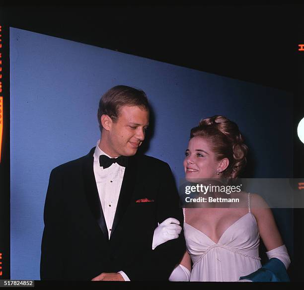 Lovely actress Sue Lyon, on the arm of her escort, attends the 37th Annual Academy Award presentations. Escort is unidentified.