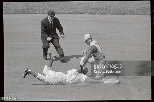 Glenn Beckert of the Cubs makes head first dive back to 2nd base just in time as Cincinnati Reds 2nd baseman Pete Rose attempts tag in 1st inning of...