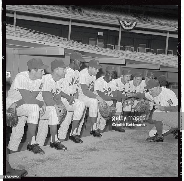New York Mets' manager Casey Stengel, , goes down on his knees as he readies his starting lineup for the season opener against the Los Angeles...